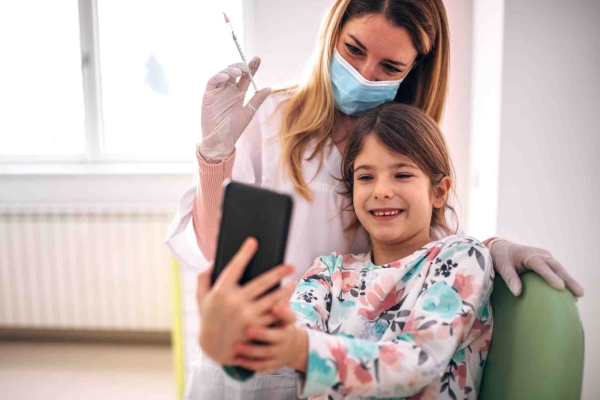 enfermera con niña sonriente haciéndose un selfie